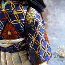 Búp bê gốm chế tác hoàn toàn thủ công, là vật mang lại may mắn trong văn hóa Nhật Bản. Trang phục gấm thêu chỉ vàng tinh xảo.