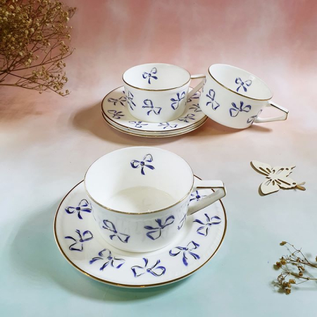 Set trà / cà phê men bóng trang trí nơ, viền vàng cua Yves Saint Laurent.